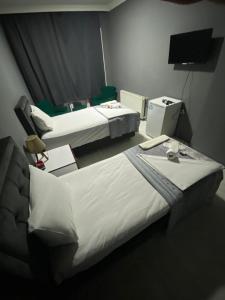 een hotelkamer met 2 bedden en een televisie bij URAZ Suit Otel in Bursa