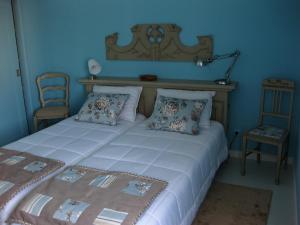 a bedroom with a large white bed and a chair at Villa Spozendus in Esposende