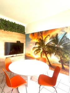 Habitación con mesa, sillas y un mural de palmeras. en Apartments Melon Vodice, en Vodice