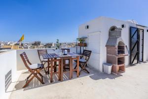 a patio with a table and chairs on a roof at Charming & elegant townhouse in central Malta in Birkirkara