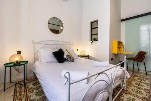 a bedroom with a white bed and a mirror at Charming & elegant townhouse in central Malta in Birkirkara