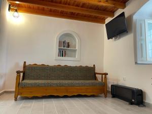 a bench in a room with a flat screen tv at Lemon House in Hydra