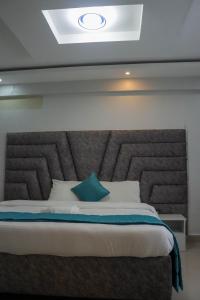 uma cama com uma grande cabeceira num quarto em BUNGOMA ROYAL SUITES em Bungoma