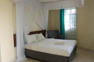 BungomaにあるBUNGOMA ROYAL SUITESのベッドルーム1室(ノートパソコン付きのベッド1台付)
