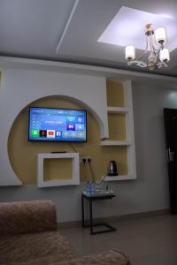 uma sala de estar com uma televisão de ecrã plano na parede em BUNGOMA ROYAL SUITES em Bungoma