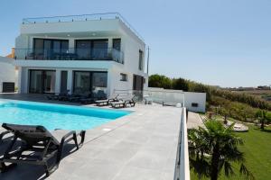 a villa with a swimming pool and a house at Villa Gold - Ocean View in Ribamar