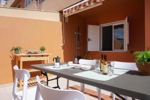 d'une terrasse avec une table, des chaises et une fenêtre. dans l'établissement Seaside Apartment in Puertito de Güímar, à Puertito de Güímar