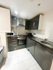 a kitchen with stainless steel appliances and a sink at Grays apartment in London