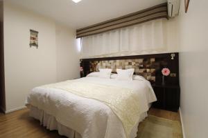 a bedroom with a large white bed with a window at Atankalama in Calama