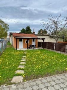 a house with a yard with yellow flowers in the grass at Apartment Terra in Čakovec