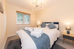 a bedroom with a large bed with white sheets at 2 Bedroom Flat Free Parking in Reading