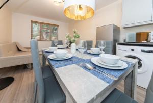 a kitchen and dining room with a table with plates and wine glasses at 2 Bedroom Flat Free Parking in Reading