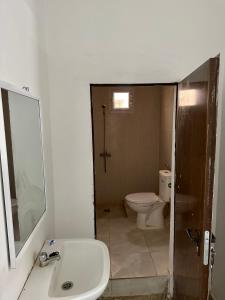 ein Badezimmer mit einem WC, einem Waschbecken und einem Spiegel in der Unterkunft Duplex neuf meublé in Nouakchott