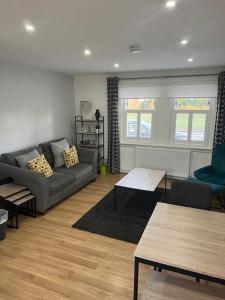 ein Wohnzimmer mit einem Sofa und einem Tisch in der Unterkunft No55 on Gilmour Street in Eaglesham