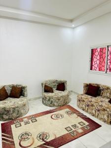 una sala de estar con 2 sofás y una alfombra en Duplex neuf meublé, en Nouakchott