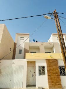 a white house with a street light at Duplex neuf meublé in Nouakchott
