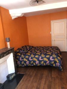 Schlafzimmer mit einem Bett und orangefarbenen Wänden in der Unterkunft Appartement centre ville Langres in Langres
