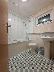 a bathroom with a toilet and a sink at BridgeCity Spacious Cottage in the Heart of Basingstoke in Worting