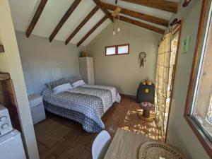 a small bedroom with a bed and a table at Cumbres de Alcohuaz in Alcoguaz
