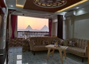 un soggiorno con divani e un tavolo di Isis Guest House a Il Cairo