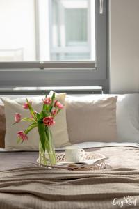 un jarrón de flores sentado en una cama en Grunwaldzka 12 C22 Easy - Rent Apartments - 50m od plaży en Pobierowo