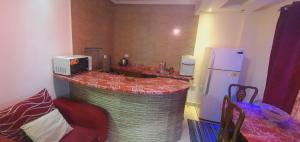 una cocina con encimera con microondas y nevera en غرفة مفروشة للايجار في مدينتي بسعر مميز, en Madinaty