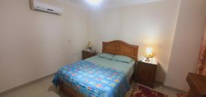 Un dormitorio con una cama y dos mesitas de noche. en غرفة مفروشة للايجار في مدينتي بسعر مميز, en Madinaty