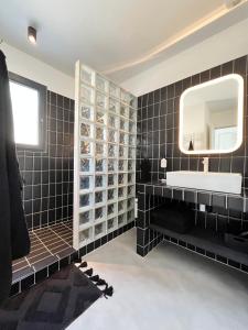 a black bathroom with a sink and a mirror at Villa Casa Papey in Draguignan