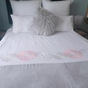 uma cama branca com flores cor-de-rosa e brancas em MaThwala guesthouse em Vanderbijlpark