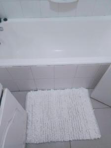 um tapete branco no chão de uma casa de banho em MaThwala guesthouse em Vanderbijlpark