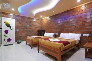 two beds in a room with a brick wall at Hillside Spring Valley Resort Masinagudi in Masinagudi