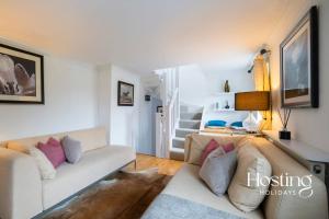 a living room with a couch and a staircase at Greys View Cottage in Henley on Thames