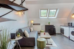 a living room with a couch and a table at Duplex Moderne à Chennevières in Chennevières-sur-Marne
