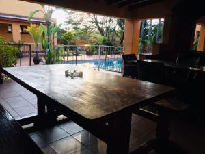 a large wooden table in a room with a patio at Inca Rose Guest House in Francistown