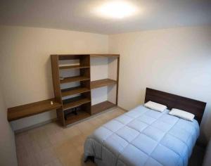 a bedroom with a bed and a book shelf at Departamento Puerta Al Mar in Conchal +22 photos