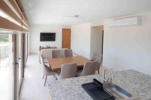 a kitchen and dining room with a table and a sink at Departamento Puerta Al Mar in Conchal