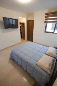 a bedroom with a bed and a tv on the wall at Departamento Puerta Al Mar in Conchal