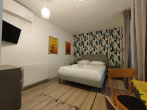 une petite chambre avec un lit et une télévision dans l'établissement Studio sur patio au coeur des Chartrons, à Bordeaux