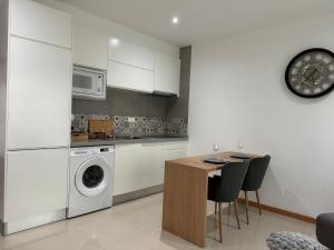 a kitchen with a washing machine and a table with chairs at SMR AP08 in Santa Maria