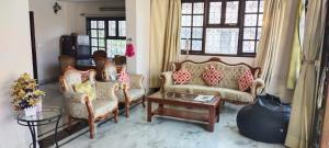 ein Wohnzimmer mit 2 Stühlen und einem Sofa in der Unterkunft Suite Room in Apartments in Bangalore