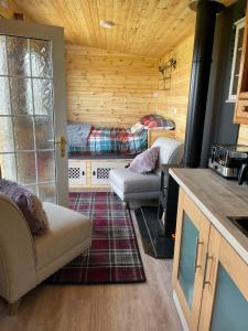uma sala de estar com duas camas num chalé de madeira em Keepers Shepherd hut with Hot Tub em Whitby