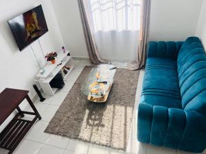 uma sala de estar com um sofá azul e uma mesa em Gianna’s Stays em Mombasa