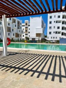 uma piscina com edifícios ao fundo em Gianna’s Stays em Mombasa