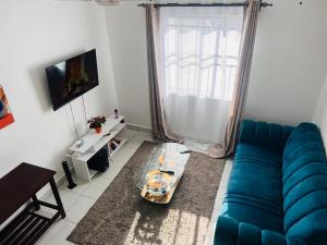 uma sala de estar com um sofá azul e uma mesa em Gianna’s Stays em Mombasa