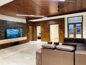 a living room with a couch and a flat screen tv at Ultra luxury 5BHK duplex in Kondapur in Kondapur