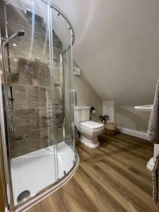 a bathroom with a toilet and a glass shower at Roseberry View Barn, Northallerton in Northallerton