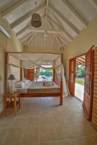 une chambre avec un grand lit dans une pièce dans l'établissement Villas Coccoloba & Jacaranda, à Capesterre