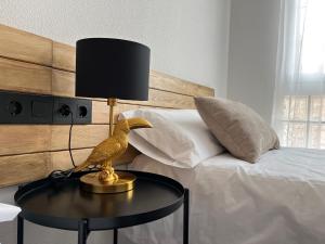 uma estátua de um pássaro numa mesa ao lado de uma cama em Casa Almendro em Jumilla