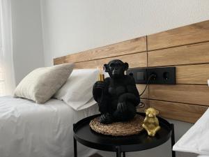 a statue of a monkey sitting on a table next to a bed at Casa Almendro in Jumilla