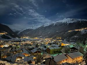 una pequeña ciudad por la noche con montañas cubiertas de nieve en Residenza Sertorelli, en Bormio